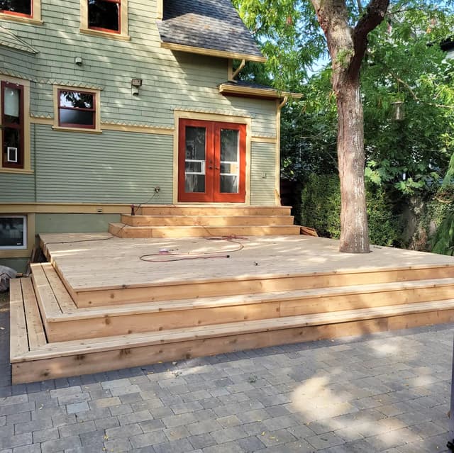 A photo of a newly built 20x20 deck with wooden steps and railings.