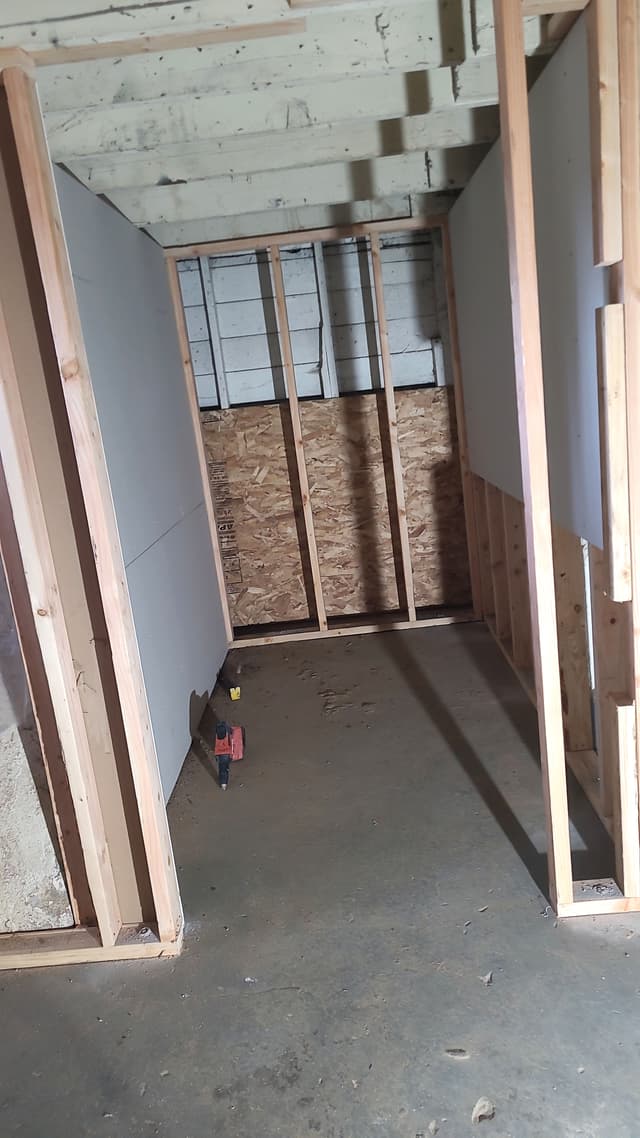 An in-progress photo of a basement with new closet framing installed.