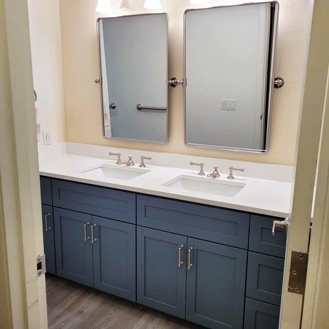 A photo of a bathroom with a new double sink vanity and large mirrors.