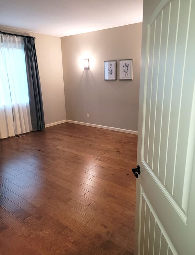 A photo of a room with new vinyl flooring, painted walls, and natural light coming through the window.