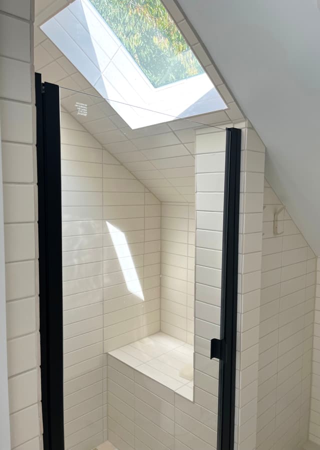 A photo of a bathroom with a tiled skylight, adding a touch of elegance and natural light.