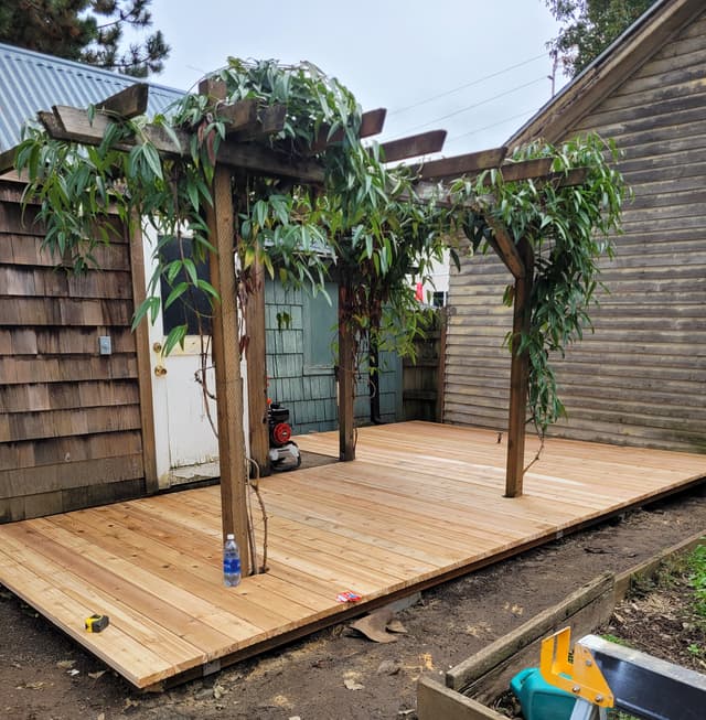 A deck with a trellis covered in climatis vines.